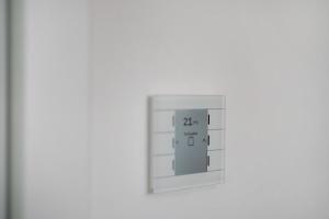 ein elektronischer Lichtschalter an einer weißen Wand in der Unterkunft Katharinenbergblick in Endingen