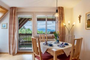 a dining room with a table and chairs and a window at Haus Scherer in Sankt Peter