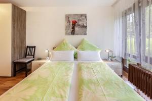a bedroom with a large bed with green and white sheets at Ferienwohnung Fetscher 1 in Reichenau +16 photos