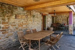 a wooden table and chairs on a patio at Lago Gabriel - Villar de Posada in Caldevilla de Rengos