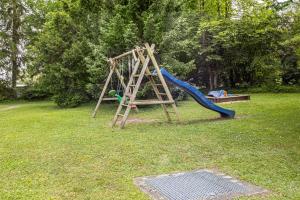 a playground with a slide and a swing set at Ferienwohnung Fetscher 1 in Reichenau