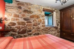 a stone walled bedroom with a bed in a room at Lorences D in Caunedo