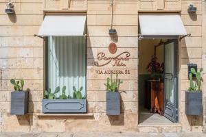 a building with two windows with plants in them at Pomona Noto in Noto