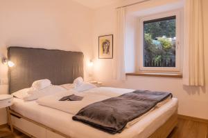 a bedroom with a large bed with a window at Appartement Rosa Seis in Kastelruth
