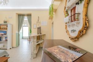 a living room with a mirror and a table at Pomona Noto in Noto