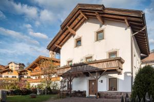 a large white building with a wooden roof at Appartement Rosa Seis in Kastelruth
