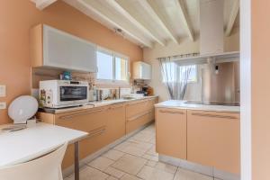 a large kitchen with a microwave and a stove at Gite Gousseau in Buzy +20 photos