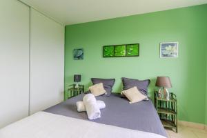 a bedroom with a large bed with green walls at Gite Gousseau in Buzy