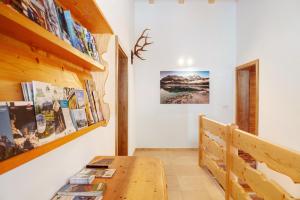 a room with a wooden table and a book shelf at Ferienwohnung Bergenzian in Grainau