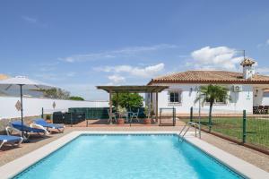 a swimming pool in front of a house at Casa Alfonso Manuel in Roche