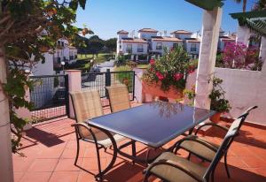 a blue table and chairs on a balcony with houses at Casa Danca Cabopino in Marbella