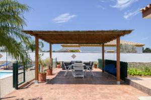 a patio with a table and chairs next to a pool at Casa Alfonso Manuel in Roche