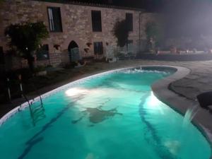 a swimming pool in front of a house at night at La Casona De Barrio in Barrio
