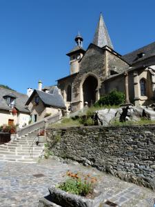 an old building with a stone wall and a church at Maison Typique Au Calme in Coubisou