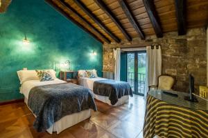 a bedroom with two beds and a stone wall at La Casona De Barrio in Barrio +24 photos