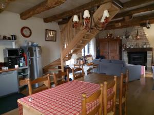a kitchen and living room with a table and a staircase at Maison Typique Au Calme in Coubisou