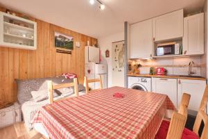 a kitchen with a table with a red and white table cloth at Appartement Le Serpaton in Gresse-en-Vercors