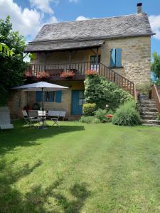 a house with a table and an umbrella on a yard at Maison Typique Au Calme in Coubisou +16 photos