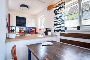 a kitchen with a wooden table and a counter at Boje by Seeblick ferien oro in Kappeln