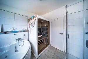 a bathroom with a tub and a toilet and a shower at Boje by Seeblick ferien oro in Kappeln +16 photos
