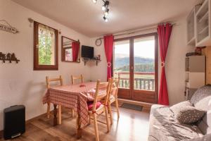 a dining room with a table and chairs and a balcony at Appartement Le Serpaton in Gresse-en-Vercors