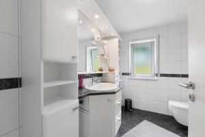 a white bathroom with a sink and a toilet at Bella Casa in Sankt Wendel +22 photos