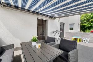 a patio with a wooden table and chairs at Bella Casa in Sankt Wendel