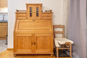 a wooden cabinet and a chair in a kitchen at Apartment Casa Gina in Stockach
