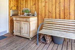 a wooden bench sitting on a wooden deck with a table at Apartment Casa Gina in Stockach +9 photos