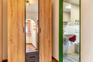 a bathroom with a wooden door and a sink at Aschaubichl - Wohnung Silberdistel in Grainau +13 photos