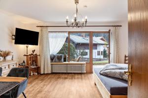 a bedroom with a bed and a large window at Aschaubichl - Wohnung Silberdistel in Grainau