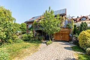 a home with a brick driveway and a house with a solarium at Apartment Casa Gina in Stockach