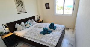 a bedroom with two beds with blue bows on them at La Cala Apartment in La Cala de Mijas +7 photos