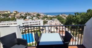 a table and chairs on a balcony with a view of a city at La Cala Apartment in La Cala de Mijas