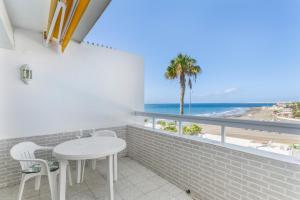 a room with a table and chairs and a view of the beach at Al Mar en San Agustín in San Bartolomé