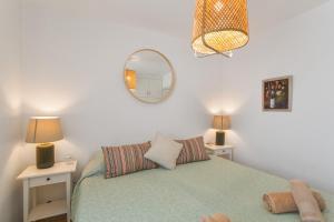 a bedroom with a bed with two tables and a mirror at Al Mar en San Agustín in San Bartolomé