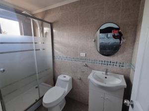 a bathroom with a toilet and a sink and a mirror at Casa campo Quillota in Quillota