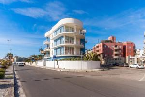 a tall white building on the side of a street at Suite Buena Vista in Gallipoli