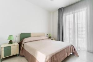 a white bedroom with a bed and a window at Suite Buena Vista in Gallipoli