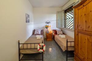 a bedroom with two beds and a window at White Sand Private Villa in Torre Squillace