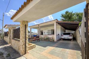 a house with a car parked in a driveway at White Sand Private Villa in Torre Squillace