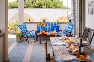 a patio with a table and chairs with food on it at White Sand Private Villa in Torre Squillace +28 photos