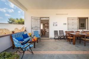 a patio with blue chairs and a wooden table at White Sand Private Villa in Torre Squillace