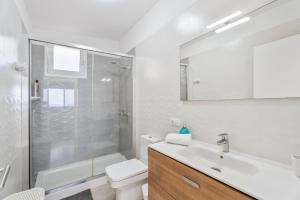 a white bathroom with a shower and a sink at Casa Miramar in Frontera +17 photos