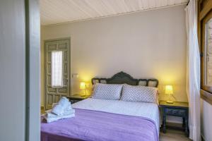 a bedroom with a bed with a purple bedspread at Apartamento Bajo 3 in Begur