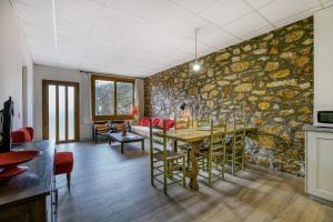 a dining room with a stone wall at Apartamento Bajo 3 in Begur