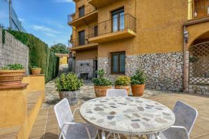 a patio with a table and chairs in front of a building at Apartamento Bajo 3 in Begur