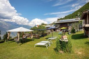 a group of tables and umbrellas in a field at Affittacamere Saint-Salod in Charvensod