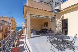 a patio with a table and chairs on a balcony at Casina di Marnie in Balestrate