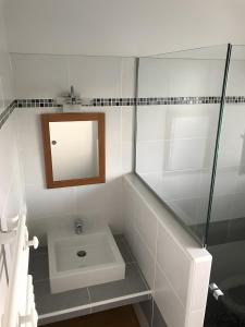 a white bathroom with a sink and a mirror at Maison Amalur in Arcangues +22 photos